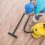 Caucasian Men Vacuuming Apartment New Hardwood Floor. Home Cleaning Time.
